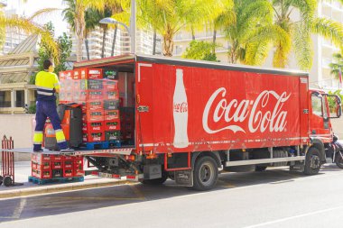 Benidorm, İspanya - 25 Şubat 2020. İçi şişe dolu kutuları olan bir adam Coca Cola markalı kamyonlardan restoranlara, barlara, kafelere içki dağıtıyor.