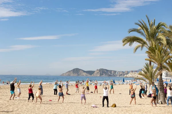 Benidorm, Espanha - 25 de fevereiro de 2020: Idosos ativos fazendo exercícios esportivos na praia. Estilo de vida saudável, aposentado ativo em Benidorm, Espanha — Fotografia de Stock