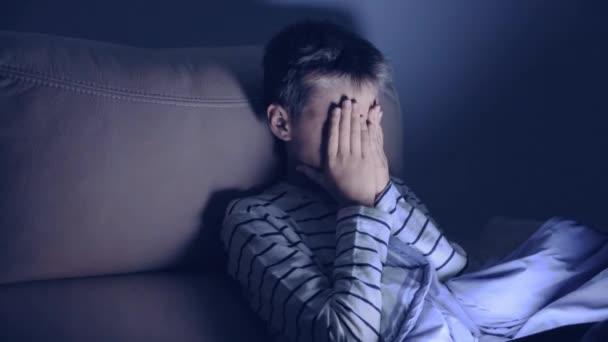 Втомлений хлопець використовує планшетний ПК вдома вночі. У дітей болять очі, тому що він грає в комп'ютерні ігри, дивиться відео, серфінг в мережі протягом тривалого часу — стокове відео