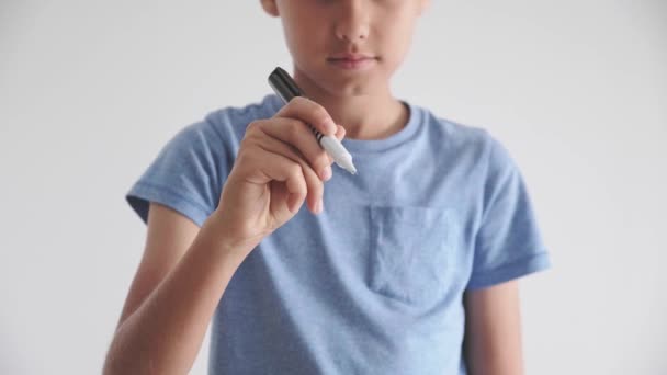 Adolescente chico de pie y escribir algo con pluma en el aire — Vídeo de stock