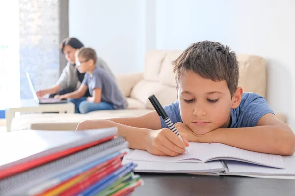 Aprendizaje en casa, aprendizaje en línea, concepto de autocuarentena. Familia en casa. Niños haciendo deberes con libros, libros de texto y con computadora en línea, la madre ayuda a los niños — Foto de Stock