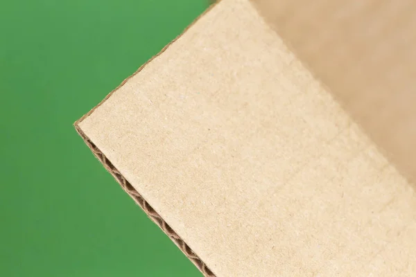 Fechar a borda da caixa de papelão aberto no fundo verde — Fotografia de Stock