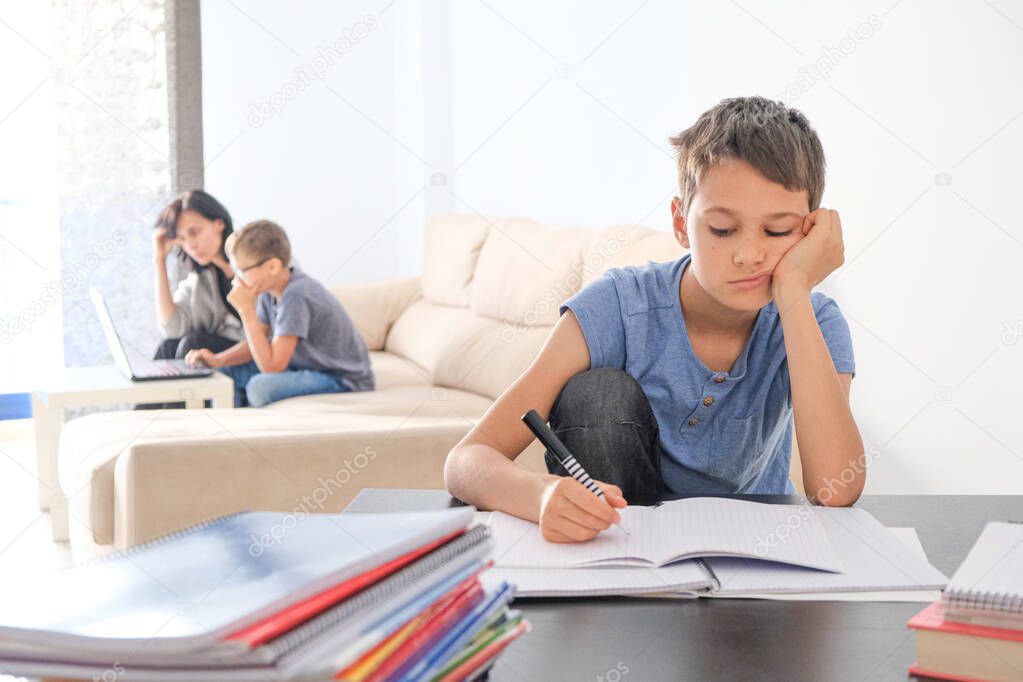 Kids doing school homework at home. Mother helping her teenager son with homework. Online learning, distance learning, homeschooling during quarantine, stay at home concept