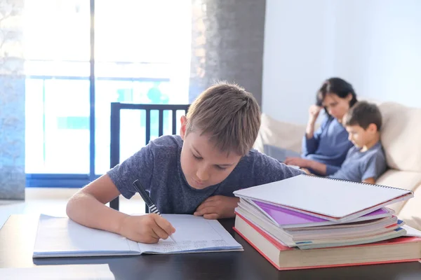 Děti dělají domácí úkoly. Matka pomáhá svému synovi s domácím úkolem a pracuje online s notebookem. Online učení, práce, nakupování, distanční vzdělávání, zůstat doma koncept — Stock fotografie