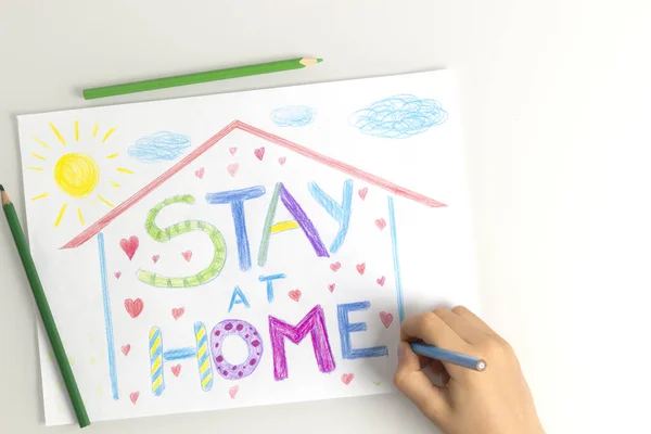 Cuarentena en casa durante la pandemia de coronavirus. Dibujo a mano de niño con lápices para colorear imagen con palabras Quédese en casa. Campaña de medios sociales para la prevención del coronavirus — Foto de Stock