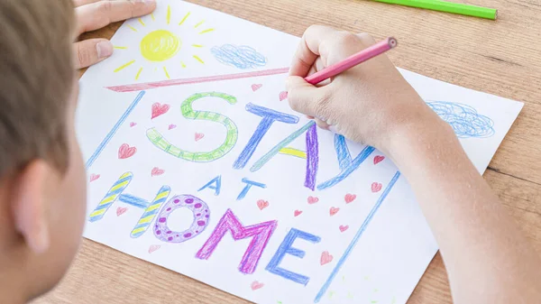 Καραντίνα στο σπίτι κατά τη διάρκεια πανδημίας του κορωνοϊού. Παιδί ζωγραφίζει με λέξεις Μείνε στο σπίτι. Εκστρατεία μέσων κοινωνικής δικτύωσης για την πρόληψη του ιού coronavirus — Φωτογραφία Αρχείου