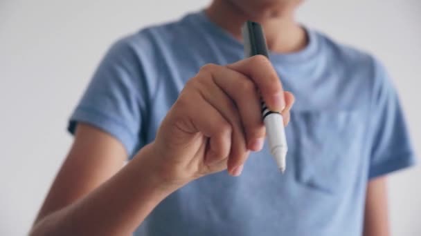 Teenager boy standing and writing something with pen in air — Stock Video