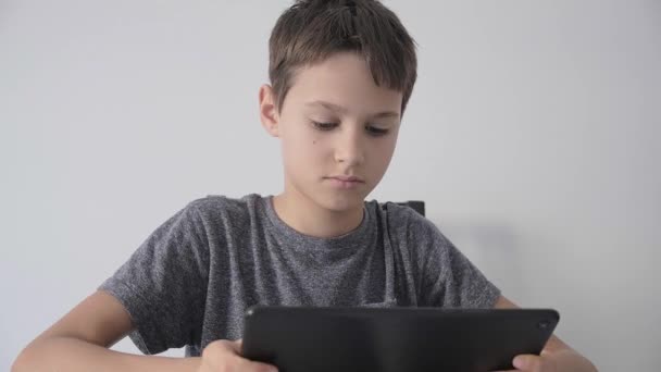 男の子はデジタルタブレットコンピュータを保持し、ビデオを見て、オンライン学習、ゲームをプレイ — ストック動画