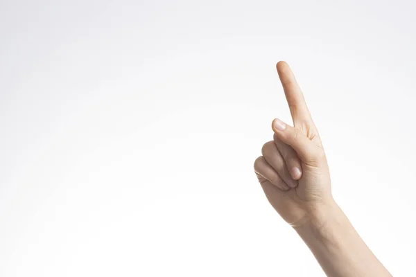 Zeigt die Hand, zeigt Geste Nummer eins mit Zeigefinger auf weißem Wandhintergrund — Stockfoto
