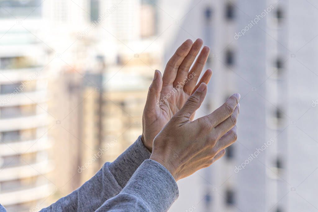 Woman hands applauding medical staff from balcony. People in Spain clapping gratitude on balconies and windows in support of health workers, doctors and nurses during the Coronavirus pandemic