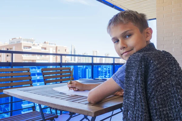 Escribir niños, hacer los deberes en el balcón. Escuela, aprendizaje en línea, educación a distancia, educación en el hogar, quedarse en el concepto de casa —  Fotos de Stock