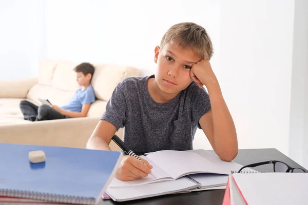 Fique em casa, aprendizagem on-line, ensino à distância, conceito de auto quarentena. Menino começar a fazer lição de casa com cadernos de livros e outro menino usando tablet digital para aula on-line em casa — Fotografia de Stock