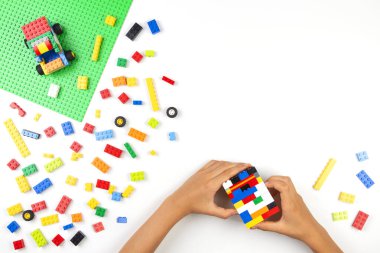 Vilnius, Litvanya - 17 Ağustos 2019: Beyaz masa üzerinde renkli Lego tuğlalarıyla oynayan çocuk elleri
