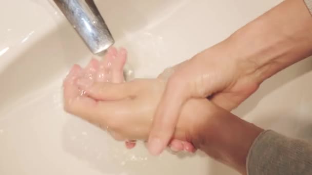 Vrouw wast handen in een gootsteen met zeep. Handen wassen om verspreiding van virus en bacteriën te voorkomen. Gezondheidszorg, schoonmaak, basishygiënevoorschriften — Stockvideo