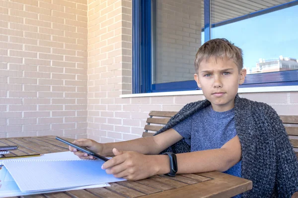 Niño con Tablet PC y libretas cuadernos haciendo deberes en balcón. Escuela, aprendizaje en línea, educación a distancia, educación en el hogar, quedarse en el concepto de casa —  Fotos de Stock