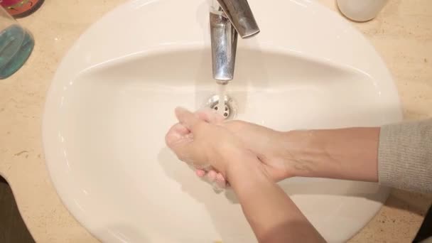 Woman washes hands in a sink with soap. Hands washing to prevention diffusion of virus and bacteria. Healthcare, cleaning, basic home hygiene rules — Stock Video