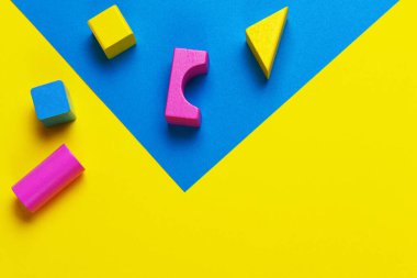 Geometrik sarı mavi arka planda ahşap renkli bloklar. Üst görünüm