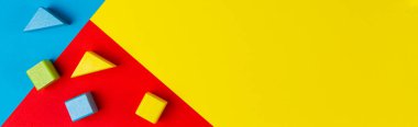 Oyuncakların afiş geçmişi. Geometrik sarı mavi arka planda ahşap renkli bloklar. Üst görünüm
