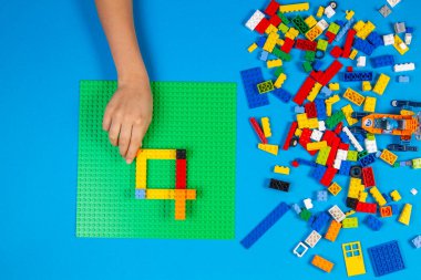 Vilnius, Litvanya - 23 Şubat 2019. Çocuklar masadaki renkli lego bloklarıyla elle oynuyorlar.