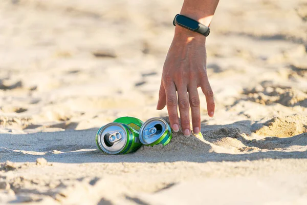 从垃圾中清理海滩。 女人手捡起海滩上的空软饮料罐垃圾 — 图库照片