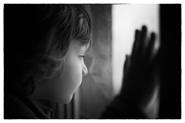 Mały chłopiec wygląda przez okno — Zdjęcie stockowe