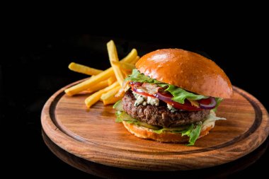 Çizburger ahşap bir domuz üzerinde patates kızartması ile