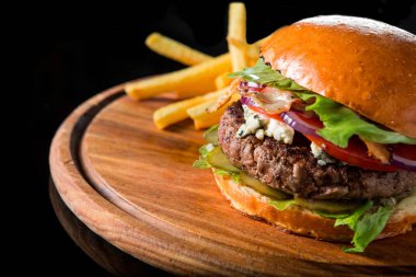 Çizburger ahşap bir domuz üzerinde patates kızartması ile