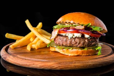 Çizburger ahşap bir domuz üzerinde patates kızartması ile