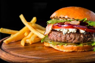 Çizburger ahşap bir domuz üzerinde patates kızartması ile