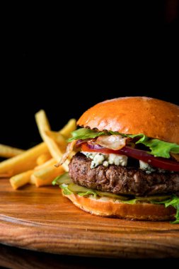 Çizburger ahşap bir domuz üzerinde patates kızartması ile
