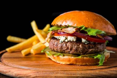 Çizburger ahşap bir domuz üzerinde patates kızartması ile