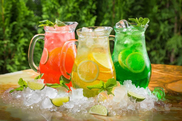 Cocktail estivi in brocche nel ghiaccio con lime e menta, sangria — Foto Stock