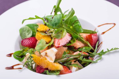 Çilekli meyve salatası, portakal peyniri ve roka dilimleri. 