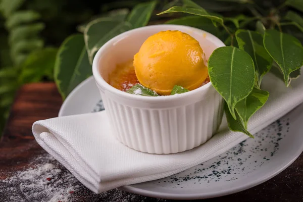 Crema brulee con menta y una cucharada de helado de naranja —  Fotos de Stock