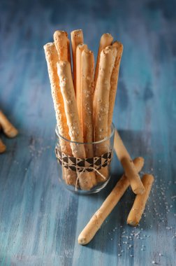 İtalyan ekmeği bir bardakta tuzlu bir masada.