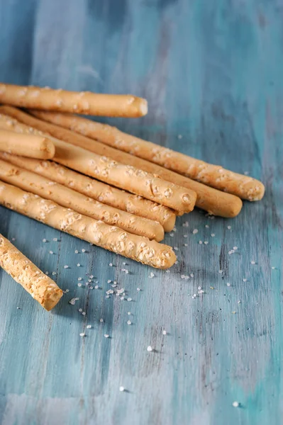 İtalyan ekmeği bir bardakta tuzlu bir masada.