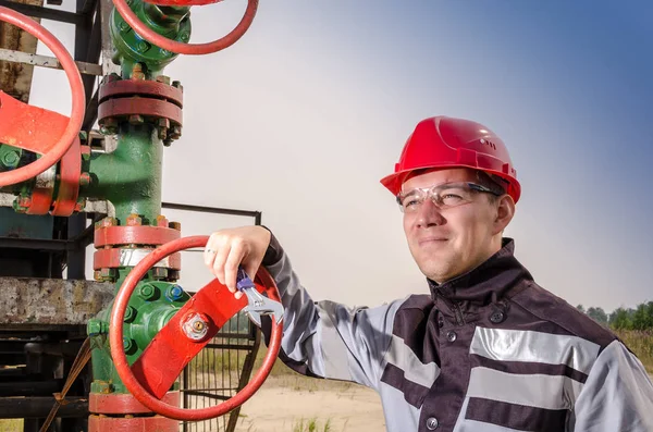 Oljefält arbetstagare nära wellhead ventil — Stockfoto