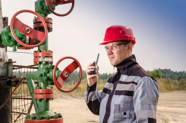 Oljefält arbetstagare nära wellhead ventil — Stockfoto