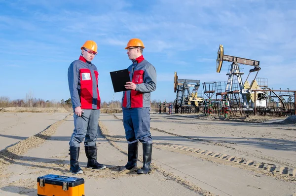 Dos trabajadores en el campo petrolero — Foto de Stock