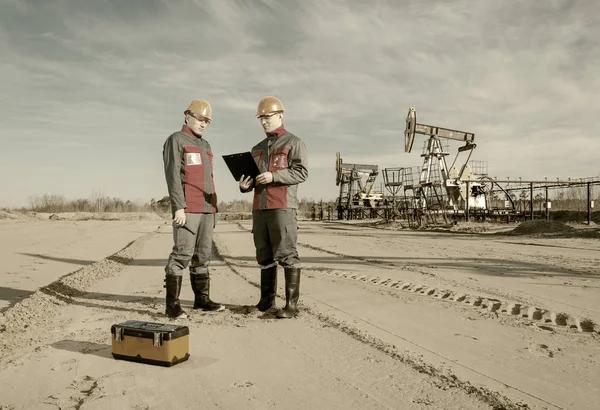 Dos trabajadores en el campo petrolero — Foto de Stock