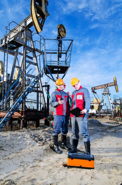 Dos trabajadores en el campo petrolero — Foto de Stock