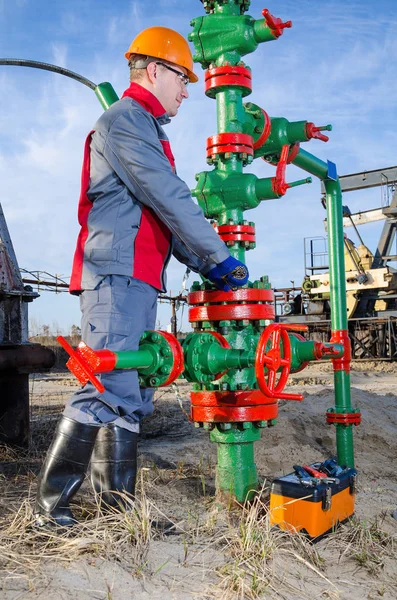 Travailleur du champ pétrolifère réparant la tête de puits — Photo