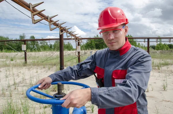 Trabajador cerca de válvula de pozo — Foto de Stock