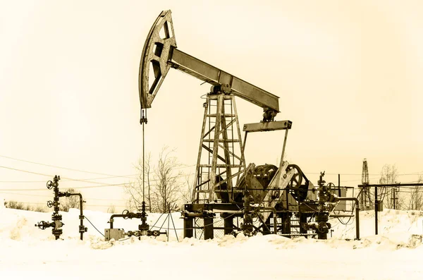 Jack bomba y cabeza de pozo en el campo petrolífero — Foto de Stock