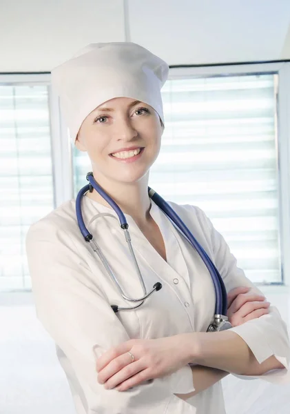 Läkare stående i vit rock och mössa — Stockfoto