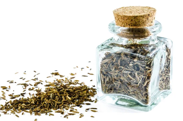 Dry cumin in glass bottle and heap of cumin isolated. — Stock Photo, Image