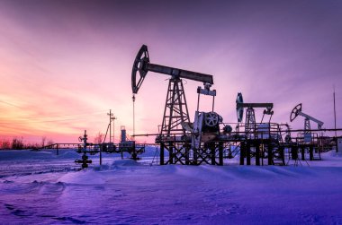 Kış zamanında günbatımı sırasında petrol sahası