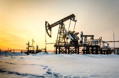 Kış zamanında günbatımı sırasında petrol sahası