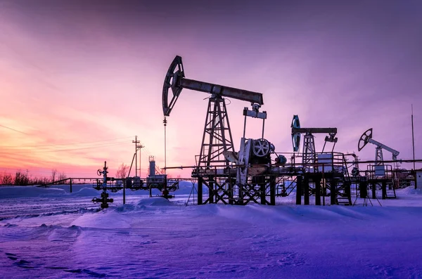 Campo petrolífero durante la puesta del sol en invierno — Foto de Stock