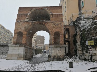 Benevento, Campania, Italy -26 February 2018: Roman Arch in Via Carlo Torre, in the Triggio district, during an unusual snowfall clipart